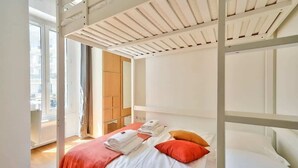 Una habitación con literas, un ventanal y vistas de la ciudad.