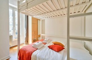 Ein Zimmer mit Etagenbett, großem Fenster und Blick auf die Stadt.