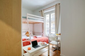 Ein Schlafzimmer mit Etagenbett, Schreibtisch mit Laptop und Stuhl.