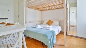 Ein Schlafzimmer mit einem Bett, einem Tisch mit Croissants, einer Holzbalkendecke und einer Schiebetür.