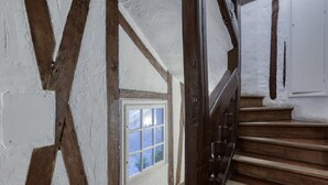 Una escalera con escalones de madera y una puerta blanca al final.