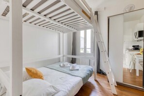 Ein Schlafzimmer mit Etagenbett, Schreibtisch und Spiegel.