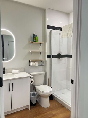 Ein modernes Badezimmer mit Toilette, Waschbecken und einer Duschkabine.