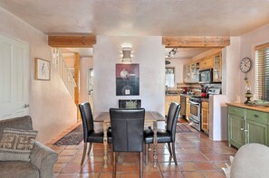 A dining area with a table and chairs, a kitchen with appliances, and a staircase leading to another level. - Casa Alto - Well-appointed, fully furnished condominium in downtown Santa Fe. (Santa Fe)