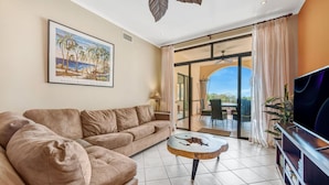 A living room with a sofa, a coffee table, a TV, and a painting. - Sunrise Tamarindo 22 (Tamarindo)
