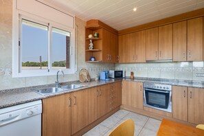 Une cuisine moderne avec des meubles en bois, un four encastré, un four à micro-ondes et un lave-vaisselle.