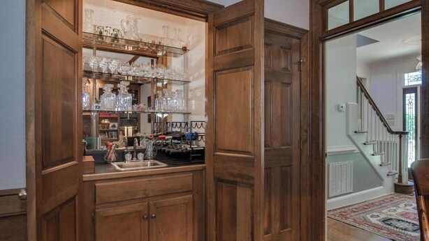 Un interno in legno con angolo cottura, una scala e un tappeto decorato.