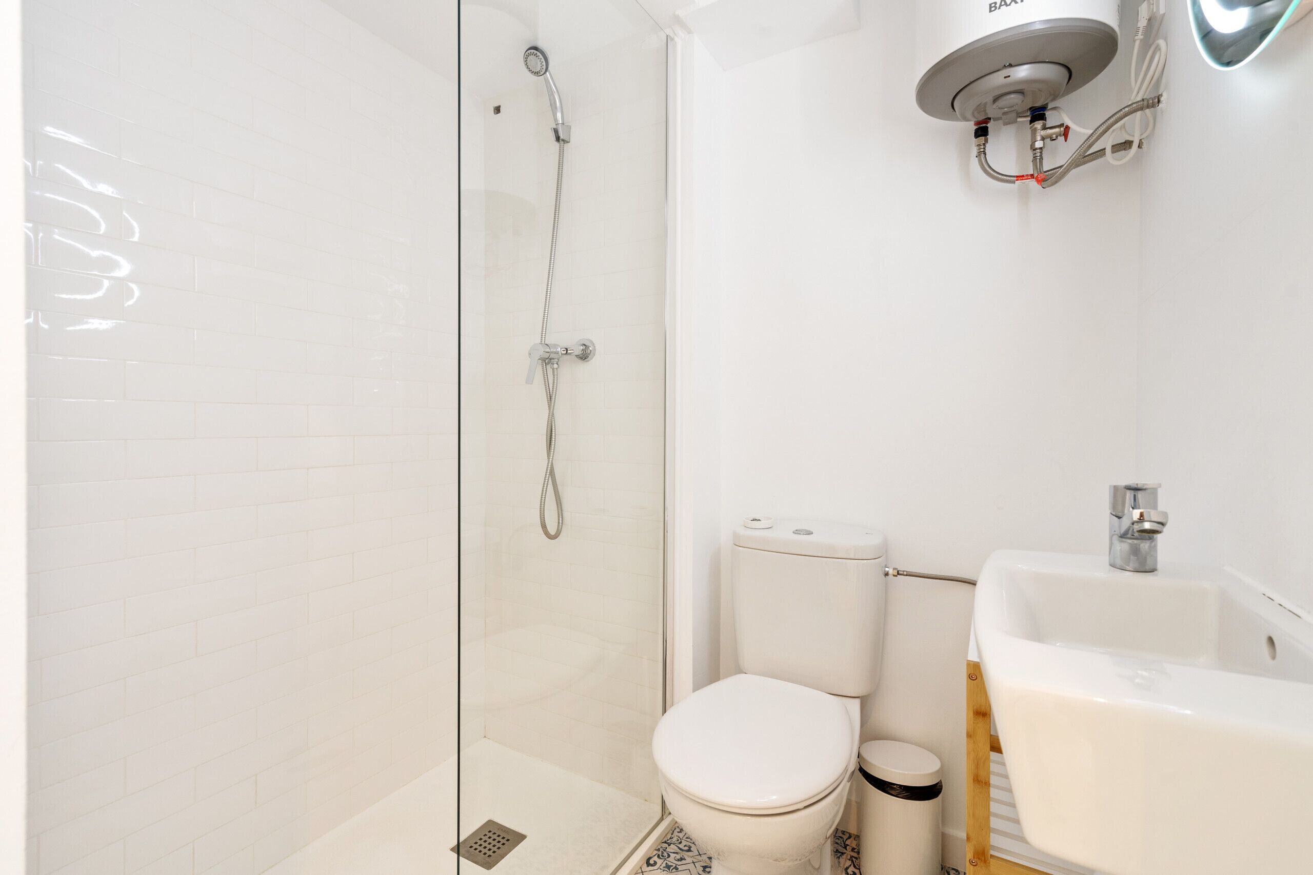 Un baño con ducha de vidrio, inodoro y lavamanos.