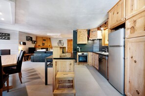 Eine moderne Küche mit Holzausstattung, einem Backofen und einem Kühlschrank.