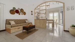 Un salón con sofá, mesa de centro y decoración mural.