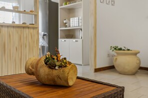 Mesa de madeira rústica com um vaso singular e diversas plantas.