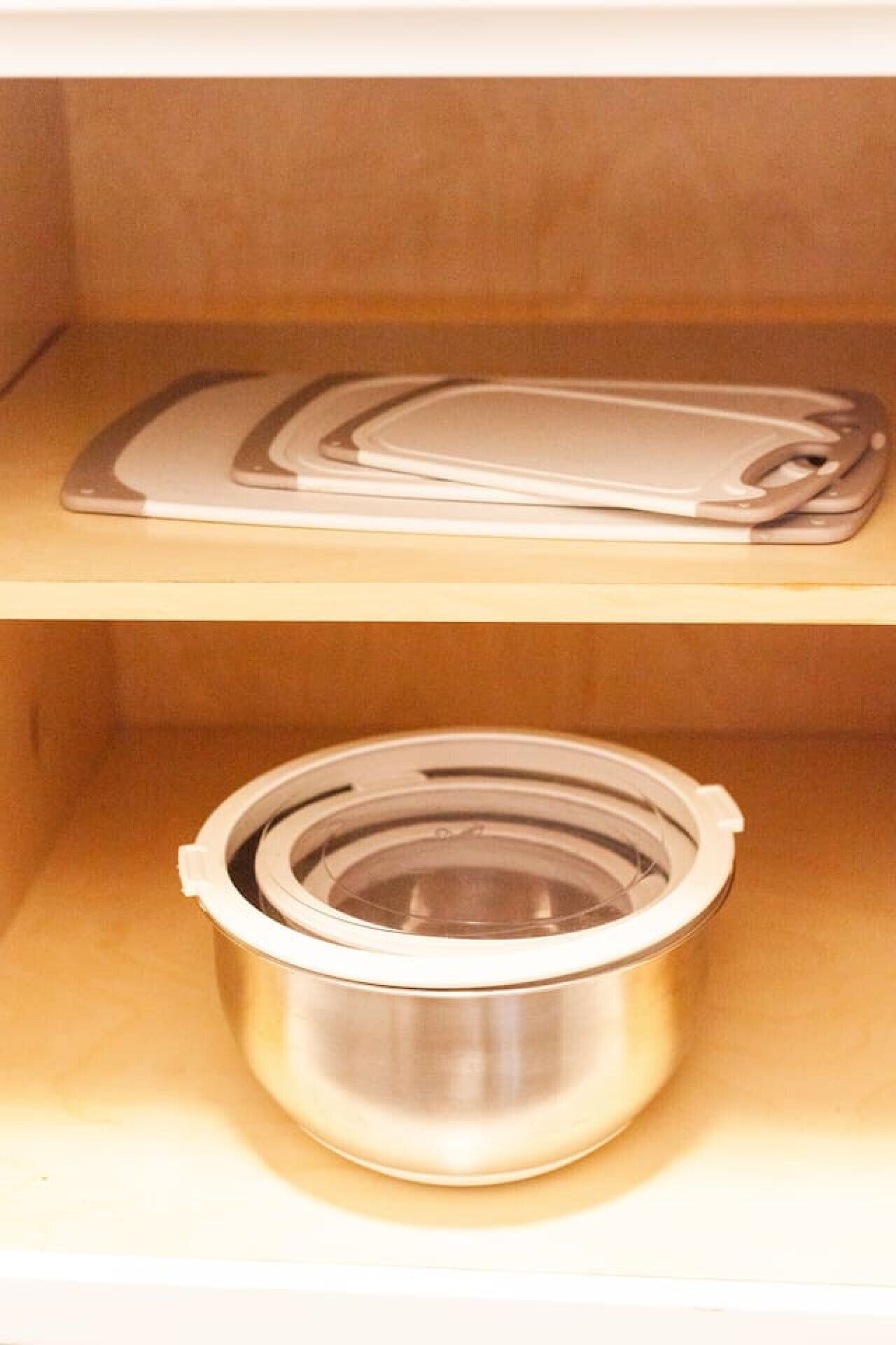 A stainless steel pot with a lid on a shelf.