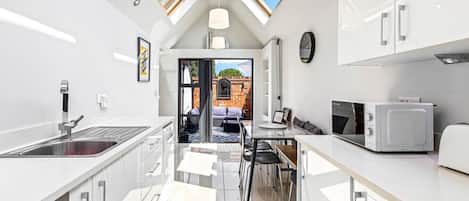 A modern kitchen with skylights, a dining area, and a view of the outside.