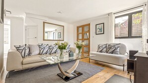 A modern living room with two sofas, a glass coffee table, and a wooden floor. - Pear Tree Cottage - pet friendly (Oxfordshire)