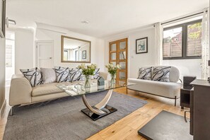 A modern living room with two sofas, a glass coffee table, and a wooden floor. - Pear Tree Cottage - pet friendly (Oxfordshire)