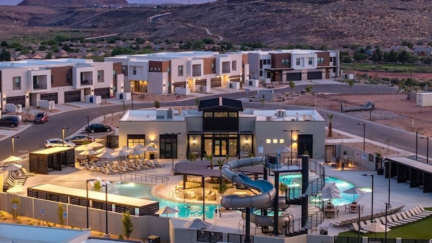 Ein Hotel mit mehreren Gebäuden, einem Schwimmbad und einer Rutsche.