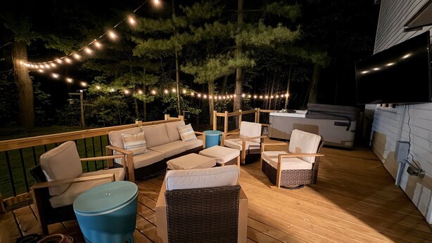 Une terrasse extérieure avec un plancher en bois, un canapé, des chaises et une table bleue.