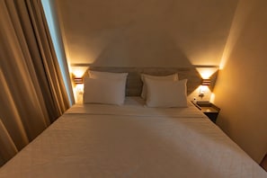 A hotel room with a bed, two bedside lamps, and a nightstand. - flat do cuca (Fernando de Noronha)