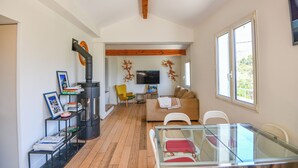 Ein modernes Wohnzimmer mit einem Glastisch, einer Couch, einem Fernseher und einem Kamin.