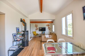 Una sala de estar moderna con una mesa de vidrio, un sofá, un televisor y una chimenea.