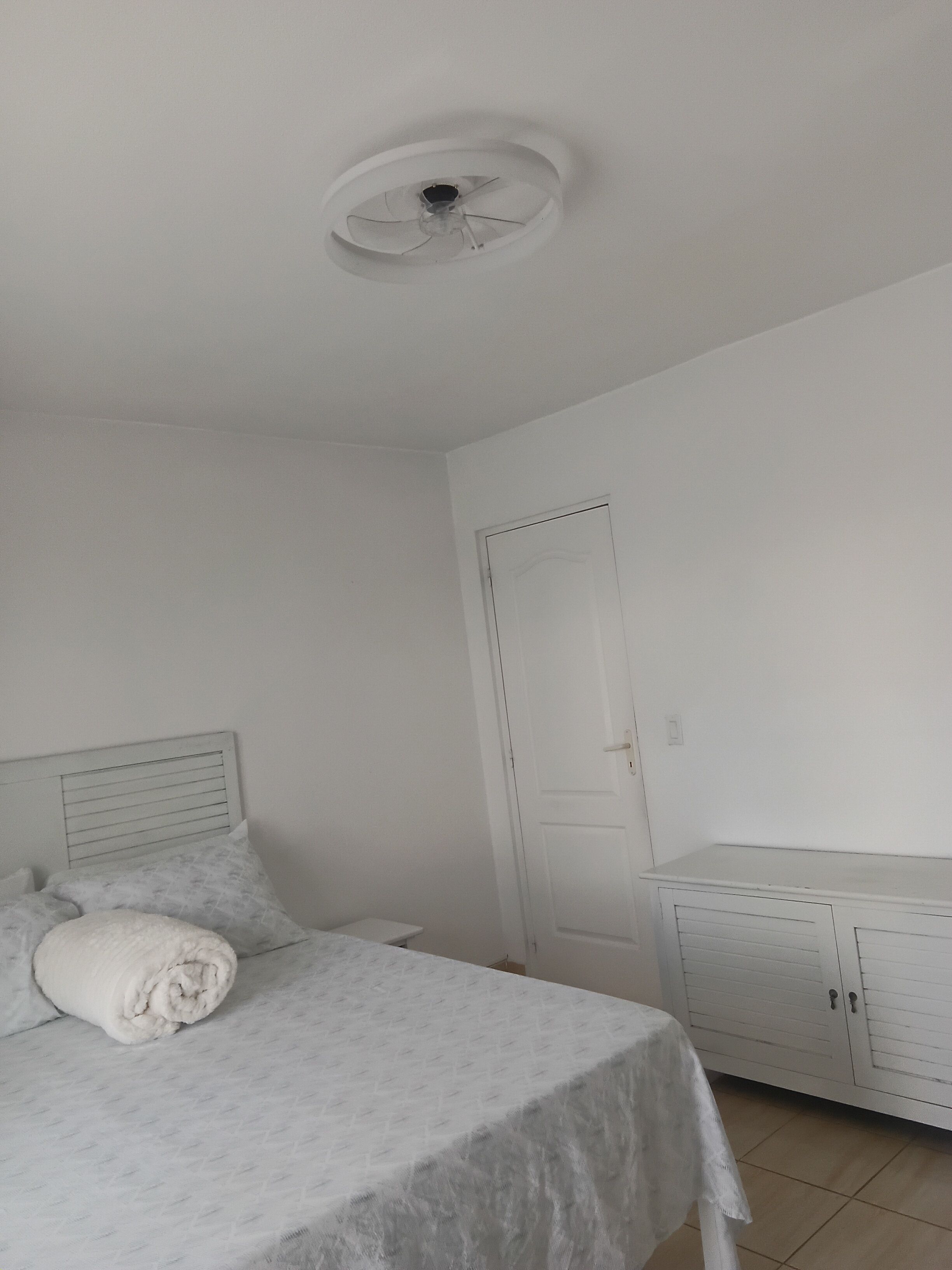 A bedroom with a bed, a wardrobe, and a door.
