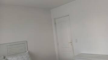 A bedroom with a bed, a wardrobe, and a door.
