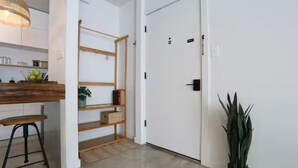 Uma cozinha moderna com bancada de madeira, um banquinho e um porta-objetos suspenso.