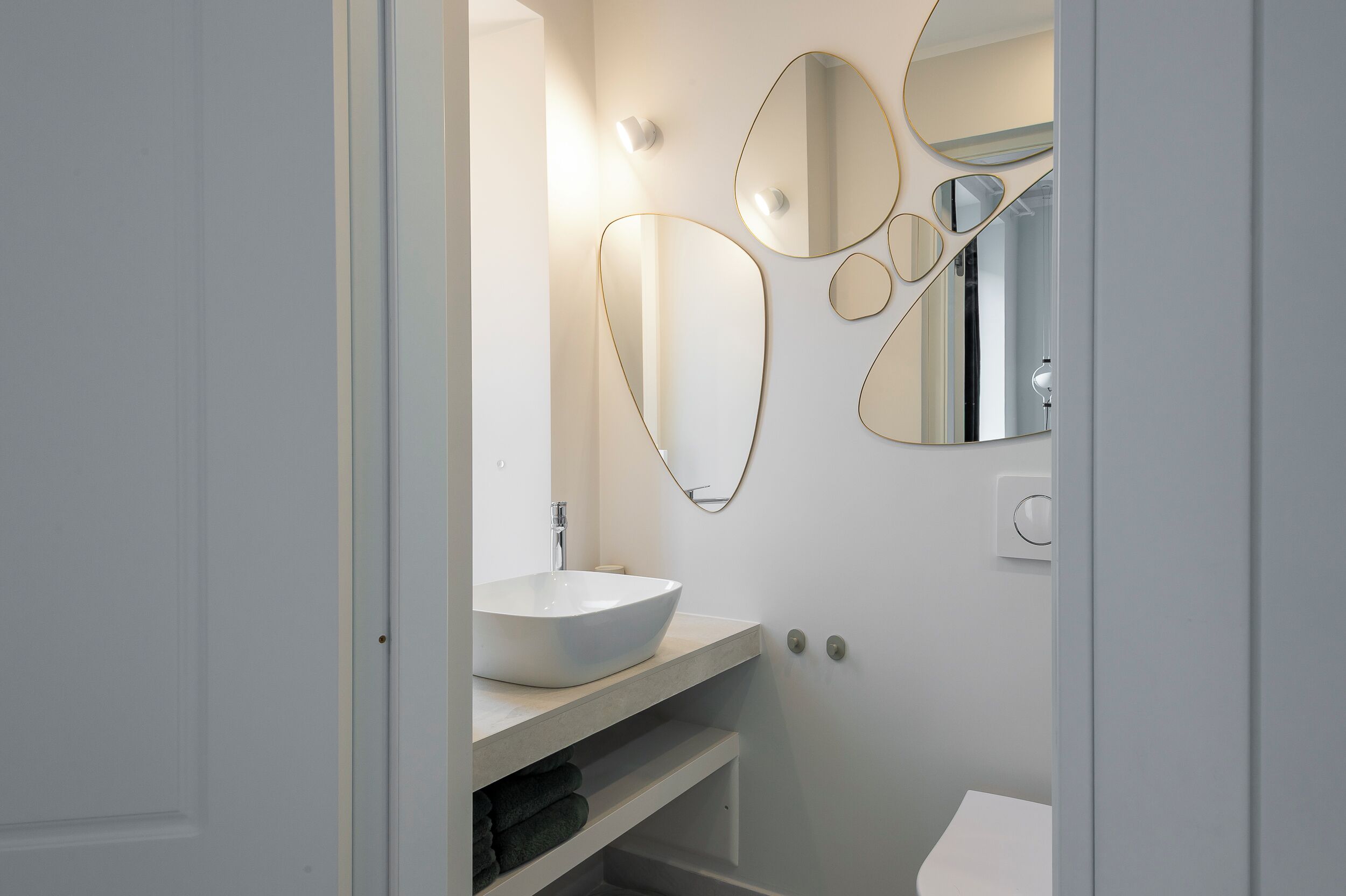 Ein modernes Badezimmer mit Waschbecken, Spiegel und Handtuchhalter.