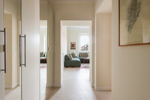 Ein Flur, der in einen Wohnbereich mit Sofa und Couchtisch führt.