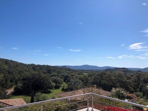 A balcony with a metal railing overlooking a lush green landscape with trees and distant hills. - Summer rental Porto-Vecchio (Porto vecchio)