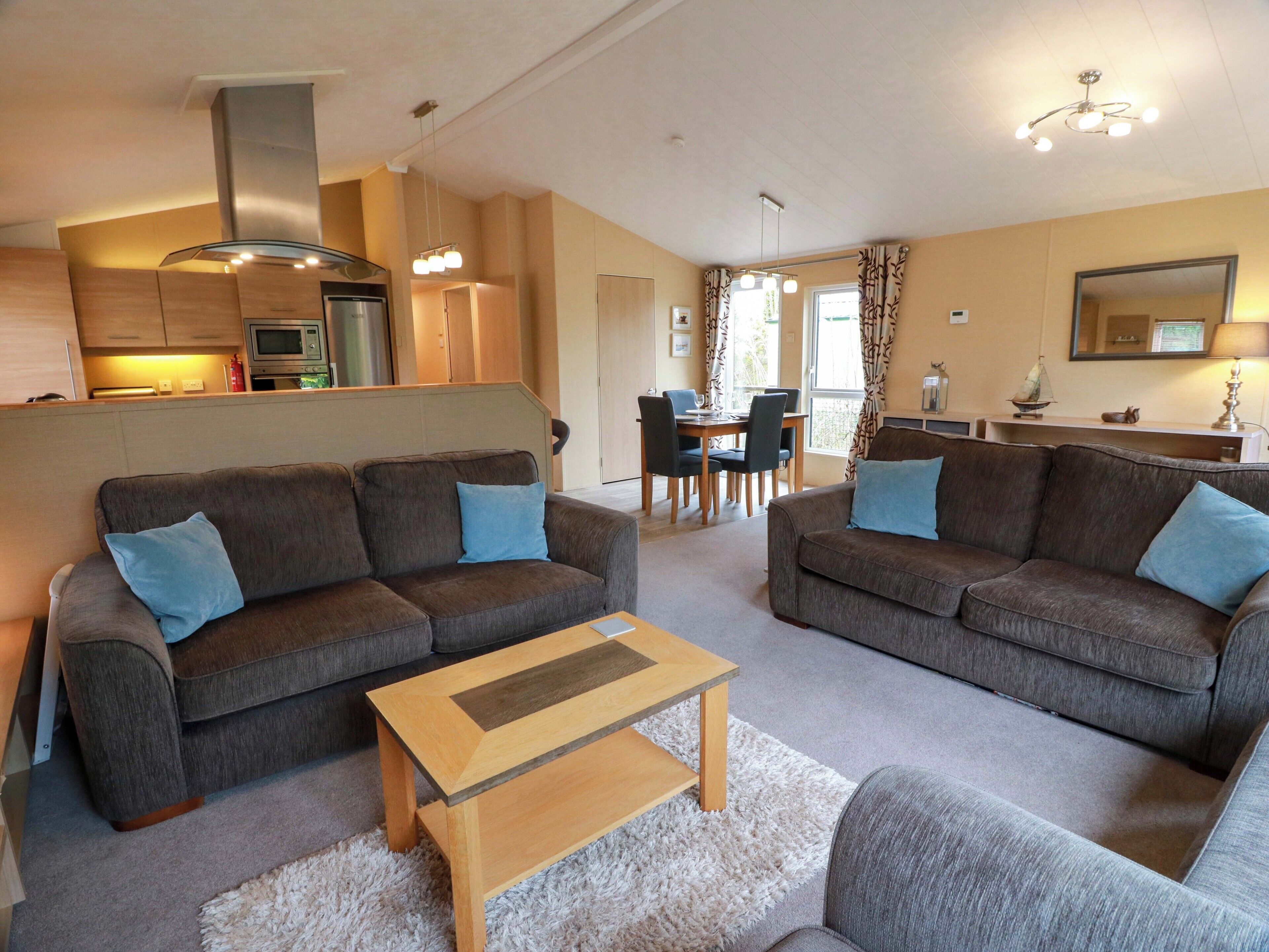 A modern living room with two sofas, a coffee table, and a dining area with a table and chairs.