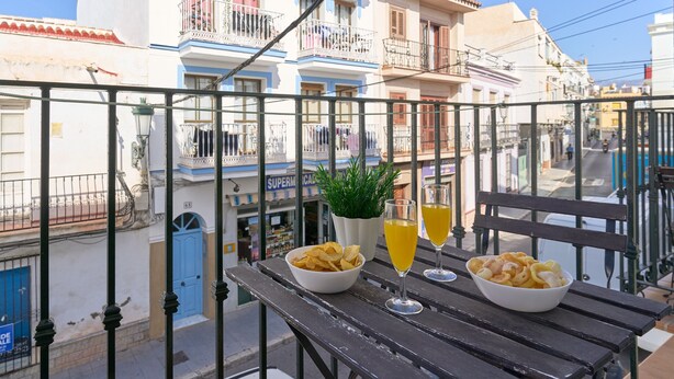 A balcony with a table, bowls of snacks, and glasses of a yellow beverage. - Apartment '1D - 2 bedrooms 4-6 people' with shared pool, Wi-Fi and air conditioning (Nerja)