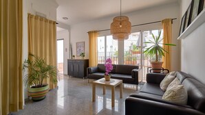 A modern living room with a sofa, a coffee table, and potted plants. - Apartment '1D - 2 bedrooms 4-6 people' with shared pool, Wi-Fi and air conditioning (Nerja)