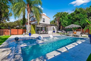A swimming pool with lounge chairs, a covered patio, and a house in the background. - MIAMI EUROPEAN SPA LIKE HOME 10 MINUTES TO THE BEACH WALK TO GOLF COURSES (Miami Shores)