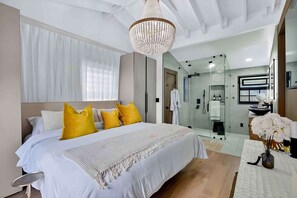 A modern hotel room with a large bed, a chandelier, a glass shower, and a bathroom with a mirror and sink. - MIAMI EUROPEAN SPA LIKE HOME 10 MINUTES TO THE BEACH WALK TO GOLF COURSES (Miami Shores)