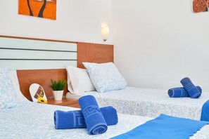 A hotel room with two beds, a wooden headboard, a wall-mounted light, and a small potted plant. - Studio '2B Studio with Balcony for 2 Guests' with Shared Pool, Wi-Fi and Air Conditioning (Nerja)