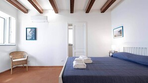 Een slaapkamer met een bed, een stoel, een deur en een raam.
