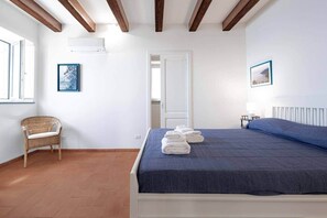 Ein Schlafzimmer mit Bett, Stuhl, Tür und Fenster.