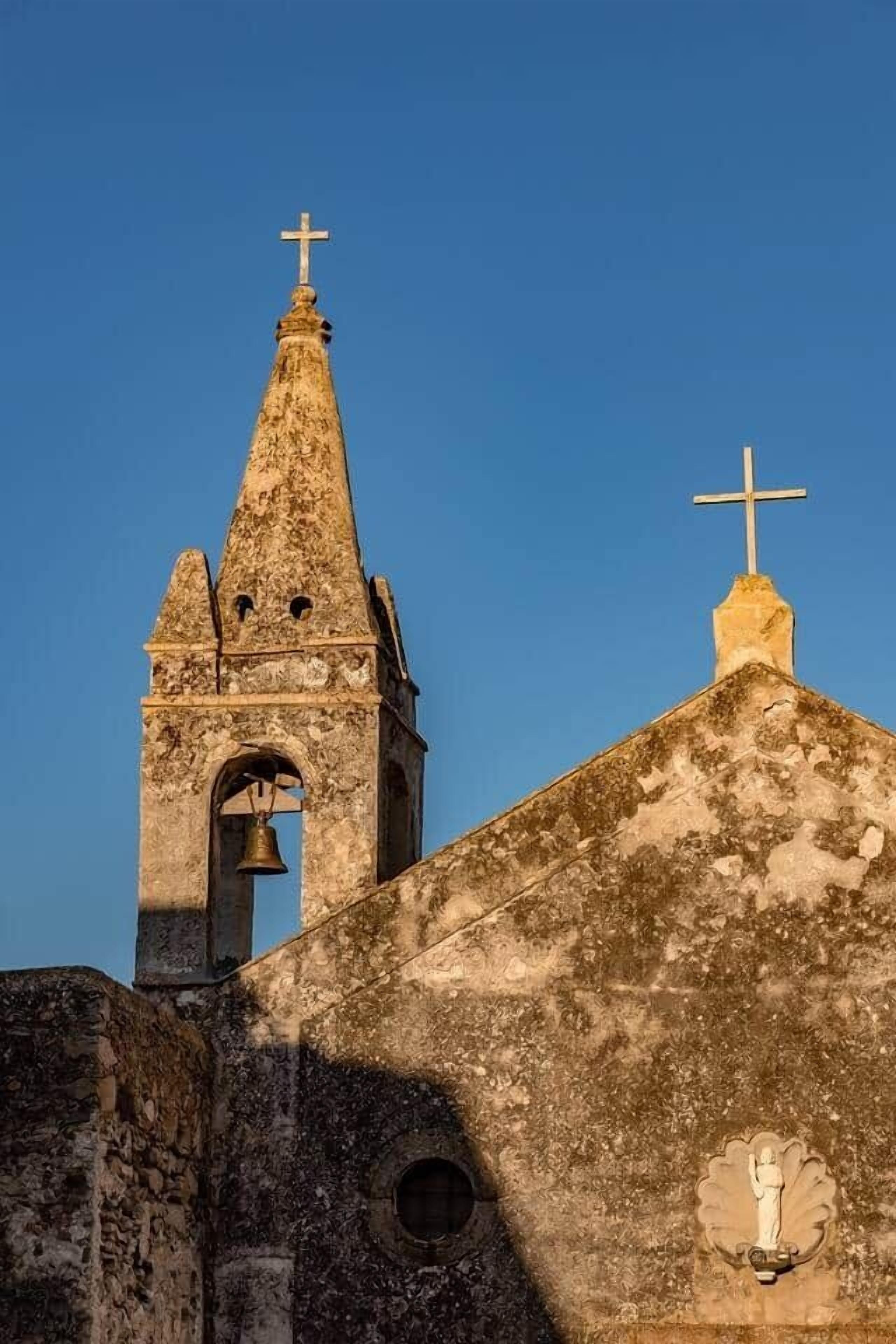 Una iglesia con un campanario y una cruz en la parte superior.