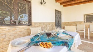 A dining table set with plates, glasses, and a bowl of food, with a decorative window and wall sconces. - APARTMENT IN VILLA MANZO (Terra Rossa)