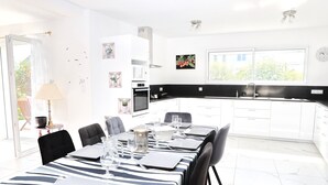 A modern kitchen with white cabinets, a black countertop, and a window.