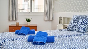 A hotel room with a bed, a nightstand, a lamp, and a view of the outside balcony. - Apartment 'P1 Duplex for 2-4 Guests' with Shared Pool, Wi-Fi and Air Conditioning (Nerja)
