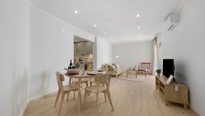 Un espai modern d'estar amb zona de dinar, cuina i seients.