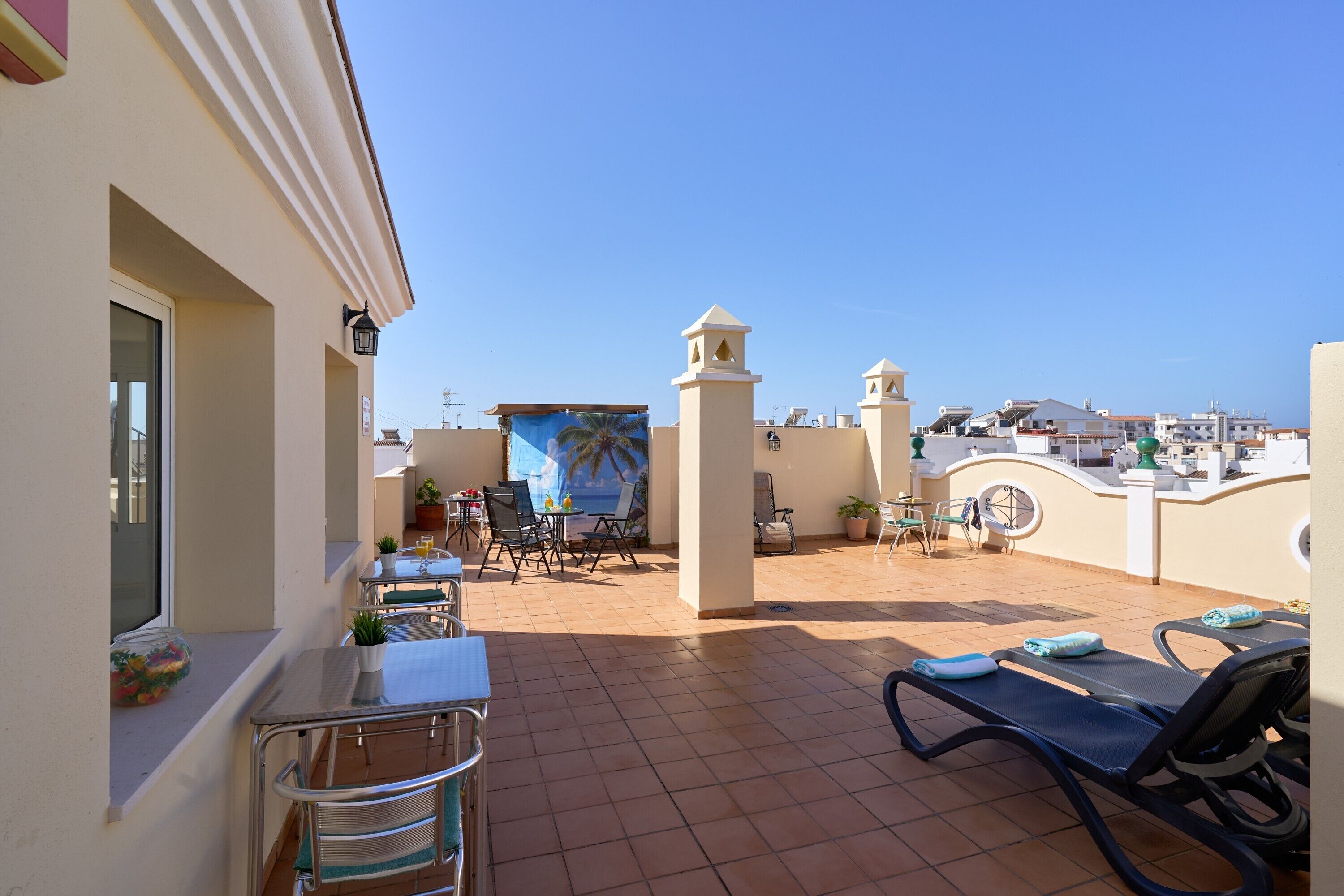 A terrace with a table, chairs, and a mural.