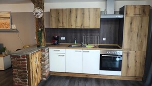 Eine Küche mit Holzausstattung, Geschirrspüler, Backofen und Kaffeemaschine.