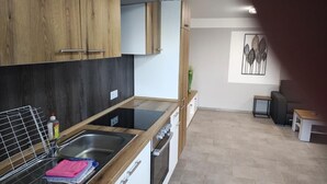 Eine moderne Küche mit Holzschränken, einem Spülbecken und einer Arbeitsplatte.