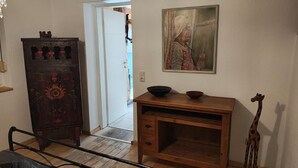 Un meuble en bois orné de motifs floraux sculptés, un bureau en bois avec un bol, et une figurine de girafe.