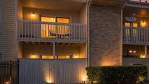 A multi-story building with balconies, a brick section, and outdoor lighting. - 2-bedroom condo in tranquil Greater Uptown, near The Galleria Mall (Houston)