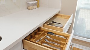 A kitchen with a white countertop, a wooden drawer organizer, and a window with a view. - 2-bedroom condo in tranquil Greater Uptown, near The Galleria Mall (Houston)