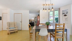 A dining area with a wooden table, chairs, and a hanging light fixture. - Room 5 – Le Toit Vert Inn: Space and Shared Moments in Moutiers (Moûtiers)